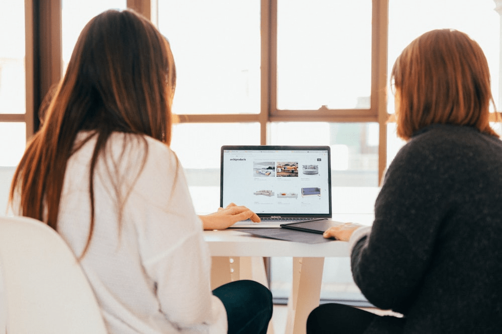 Two women checking a website’s interface.